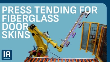 Robot placing a formed fiberglass door skin on the accumulation conveyor