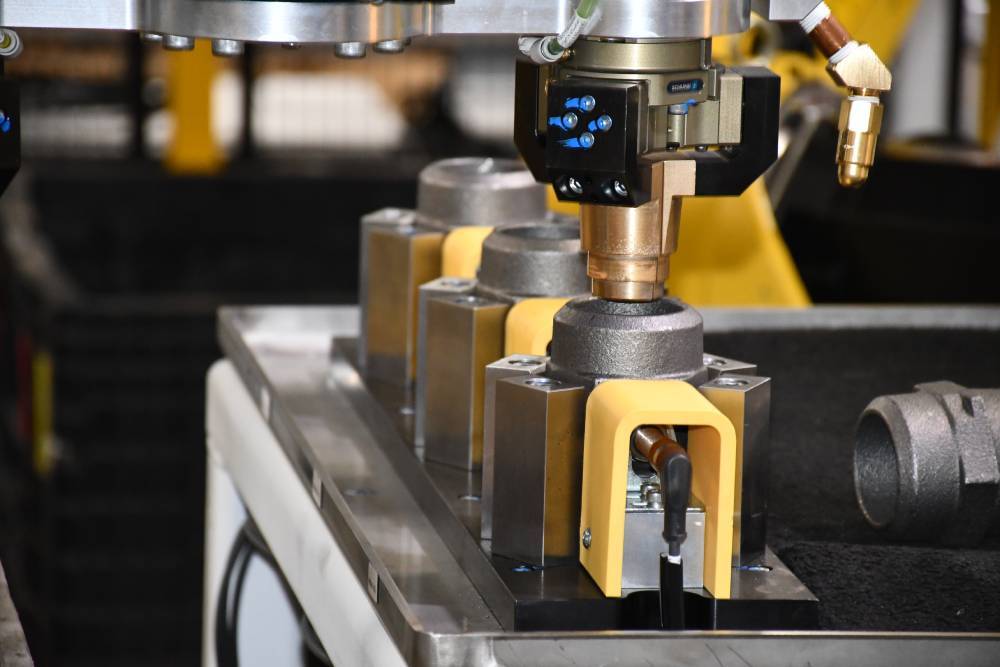 SCHUNK gripper seating a plug into a bung at the automated torquing fixture